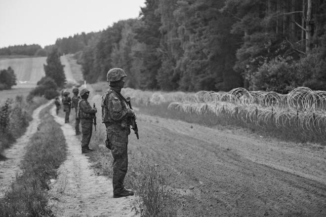 Żołnierze stoją przy lesie.