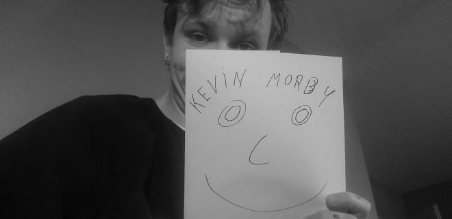 Mężczyzna z karteczką z napisem "Kevin Morby".