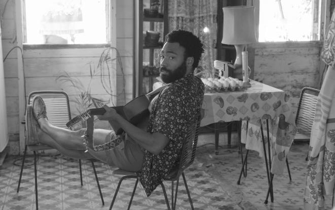 Scena z teledysku "Guava Island". Childish Gambino grający na gitarze.