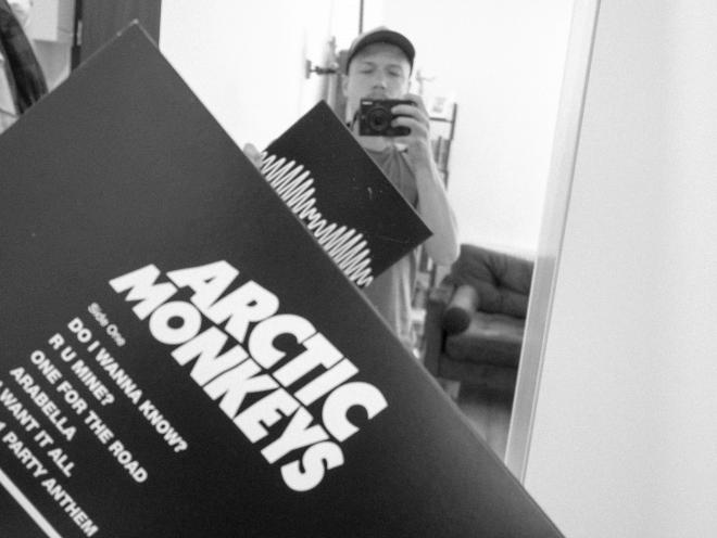 Mężczyzna robi zdjęcie w lustrze płyty zespołu Arctic Monkeys - "AM".