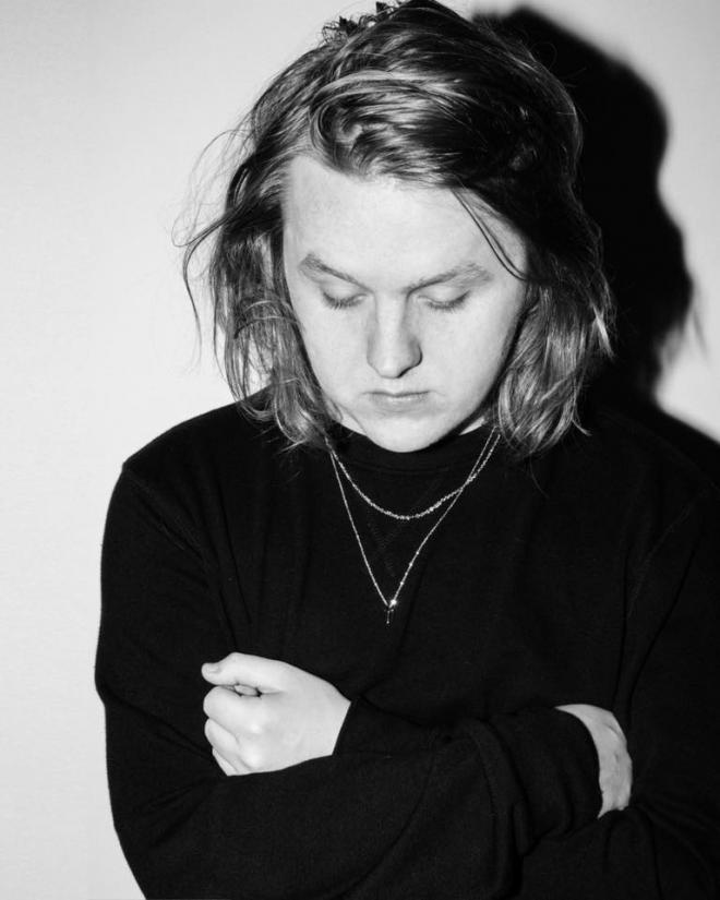 Lewis Capaldi stoi, patrzy w dół.