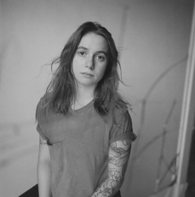 Julien Baker patrzy w obiektyw, zdjęcie portretowe.