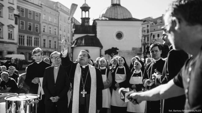 Kadr dilmu "Kler". Księża i zakonnice stojący na zewnątrz.