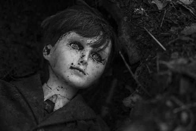 Kadr filmu "The Boy". Lalka ubrudzona ziemią.