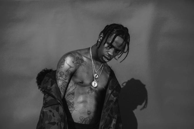 Raper Travis Scott na czerwonym tle.