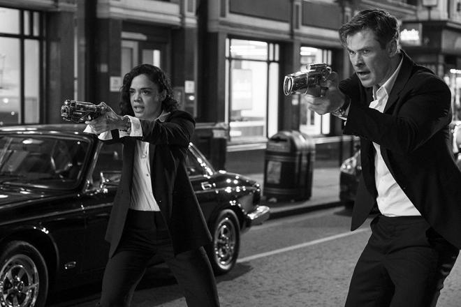 Kadr z filmu "Men in Black: International". Mężczyzna i kobieta celują bronią.