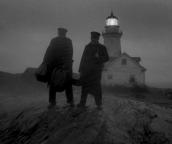 Kadr filmu "Lighthouse". Dwóch mężczyzn stoi, w tle latarnia.