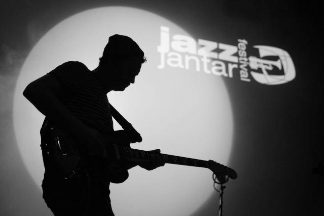 Jazz Jantar. Cień gitarzysty na tle hologramu.