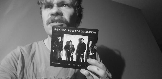 Mężczyzna trzyma płytę Iggy Pop - "Post Pop Depression".