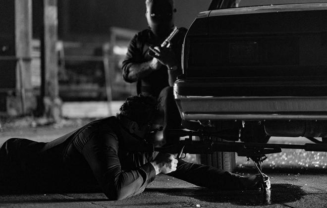 Kadr filmu "Dragged Across Concrete". Dwaj mężczyźni w maskach majsterkują przy samochodzie.